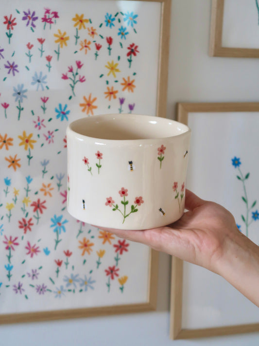 Vase with pink flowers and bees