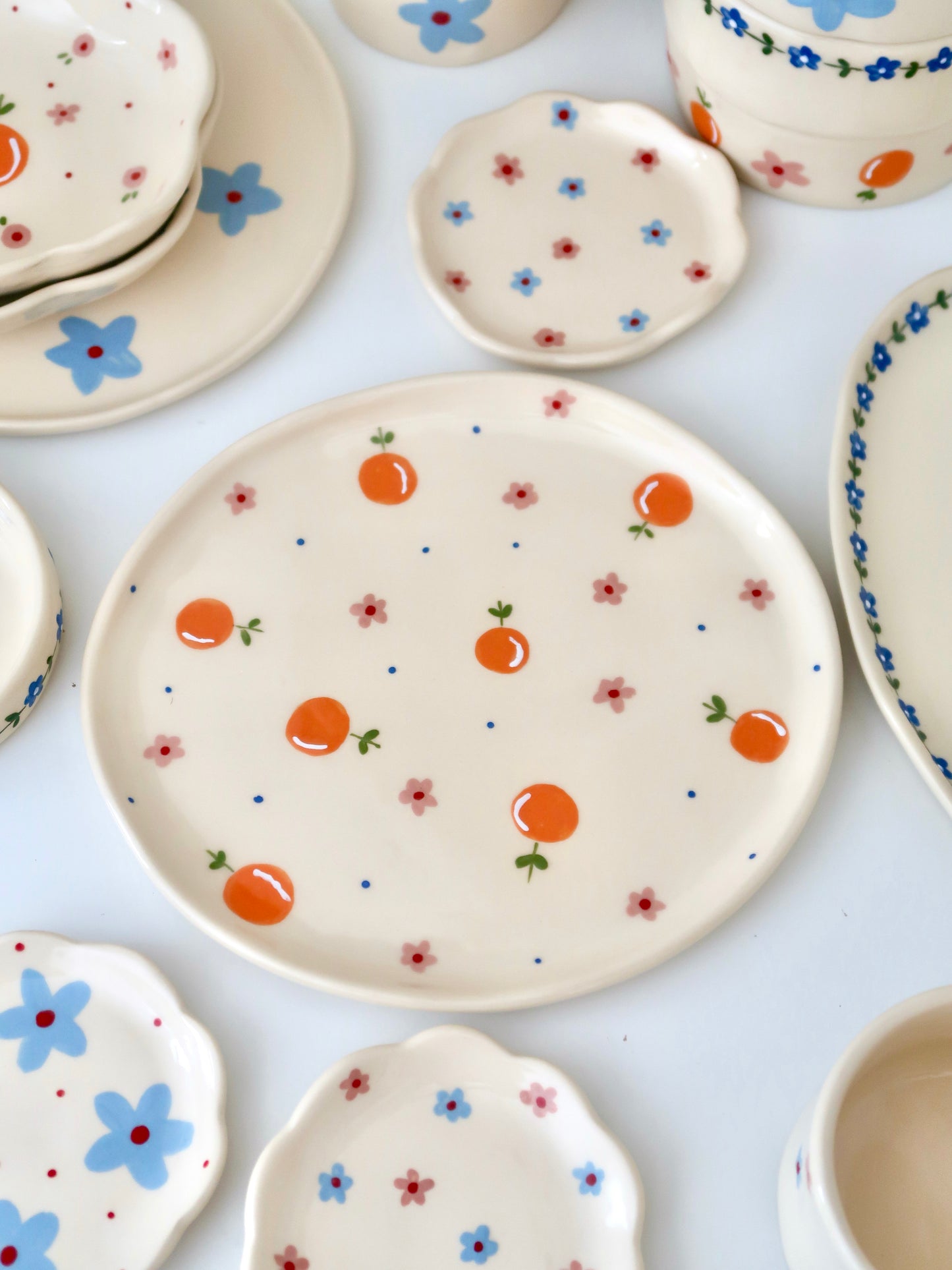 Plate with oranges, pink flowers and blue dots