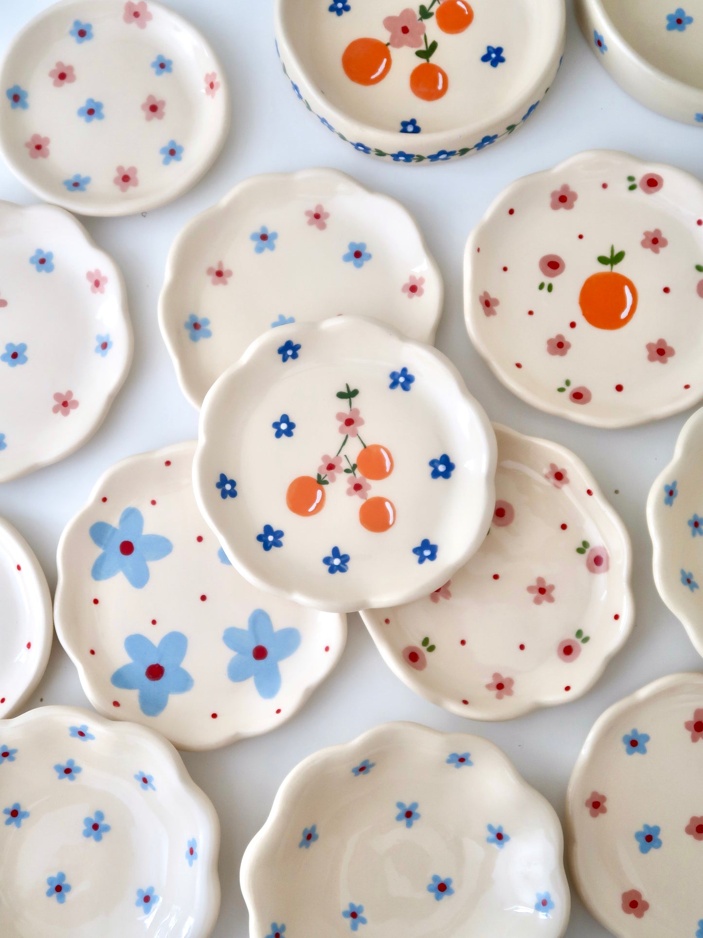 Scalloped ring dish with oranges and blue flowers