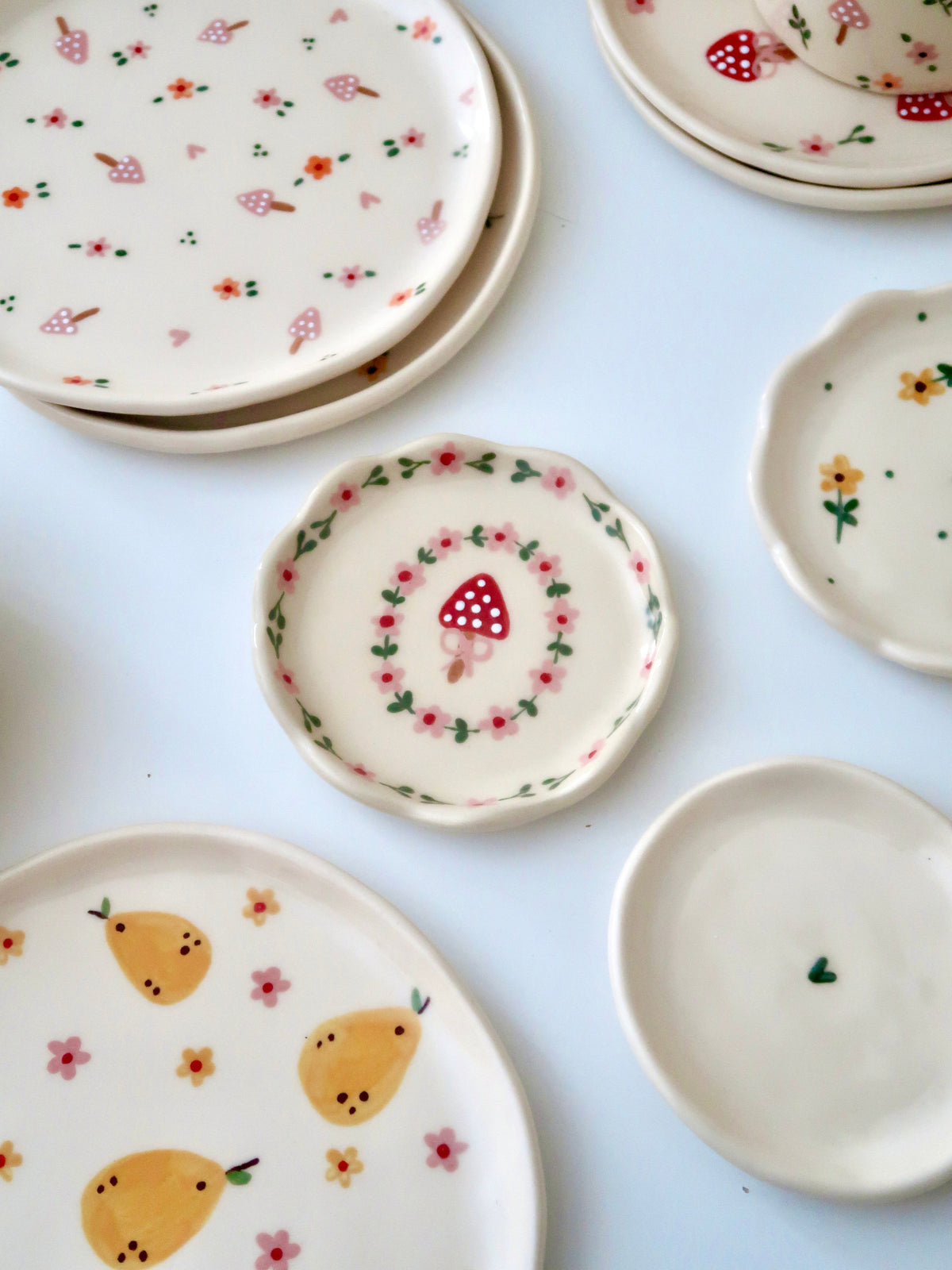 Scalloped ring dish with a mushroom and pink flowers