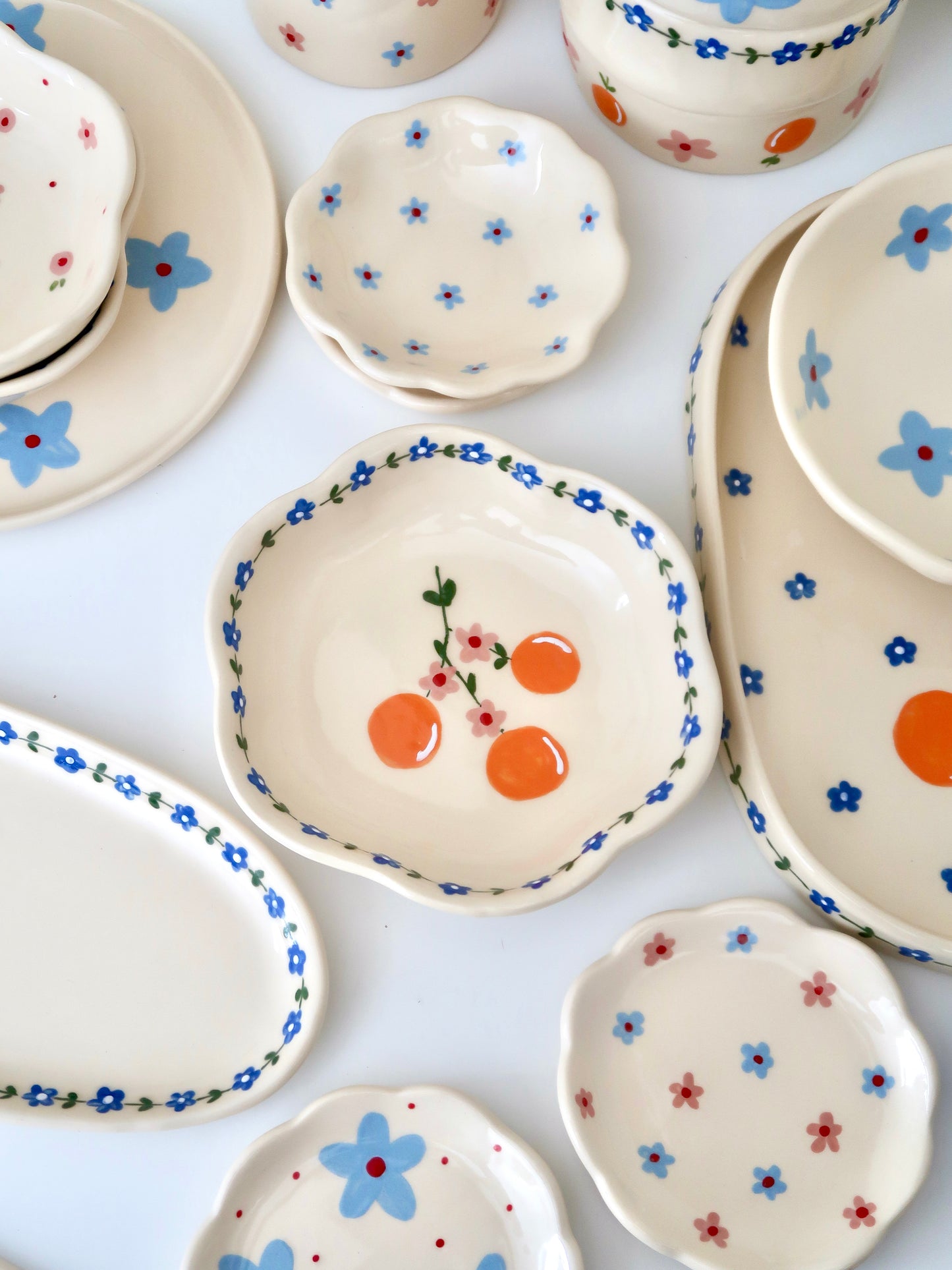 Scalloped bowl with oranges and blue flowers