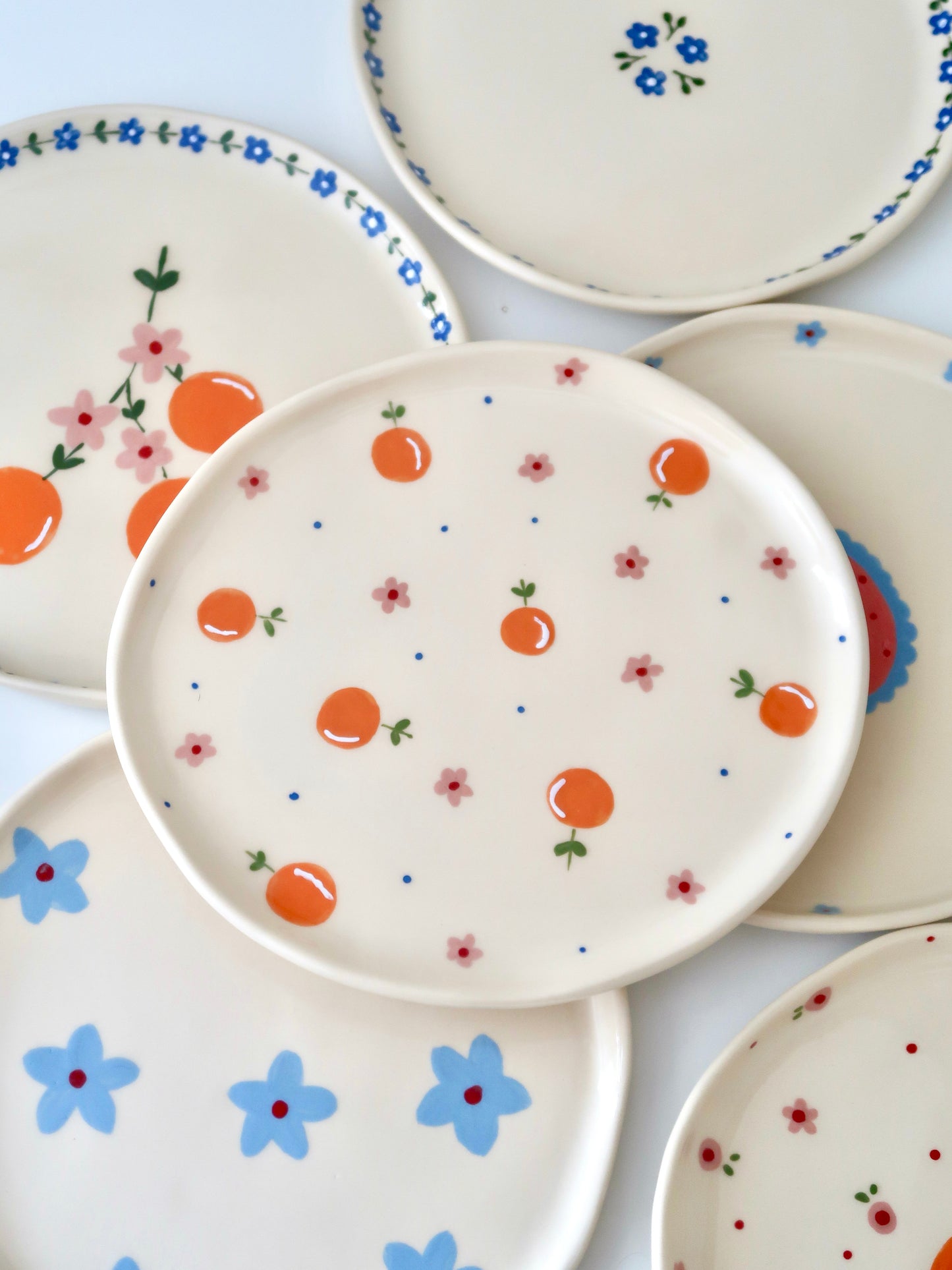 Plate with oranges, pink flowers and blue dots