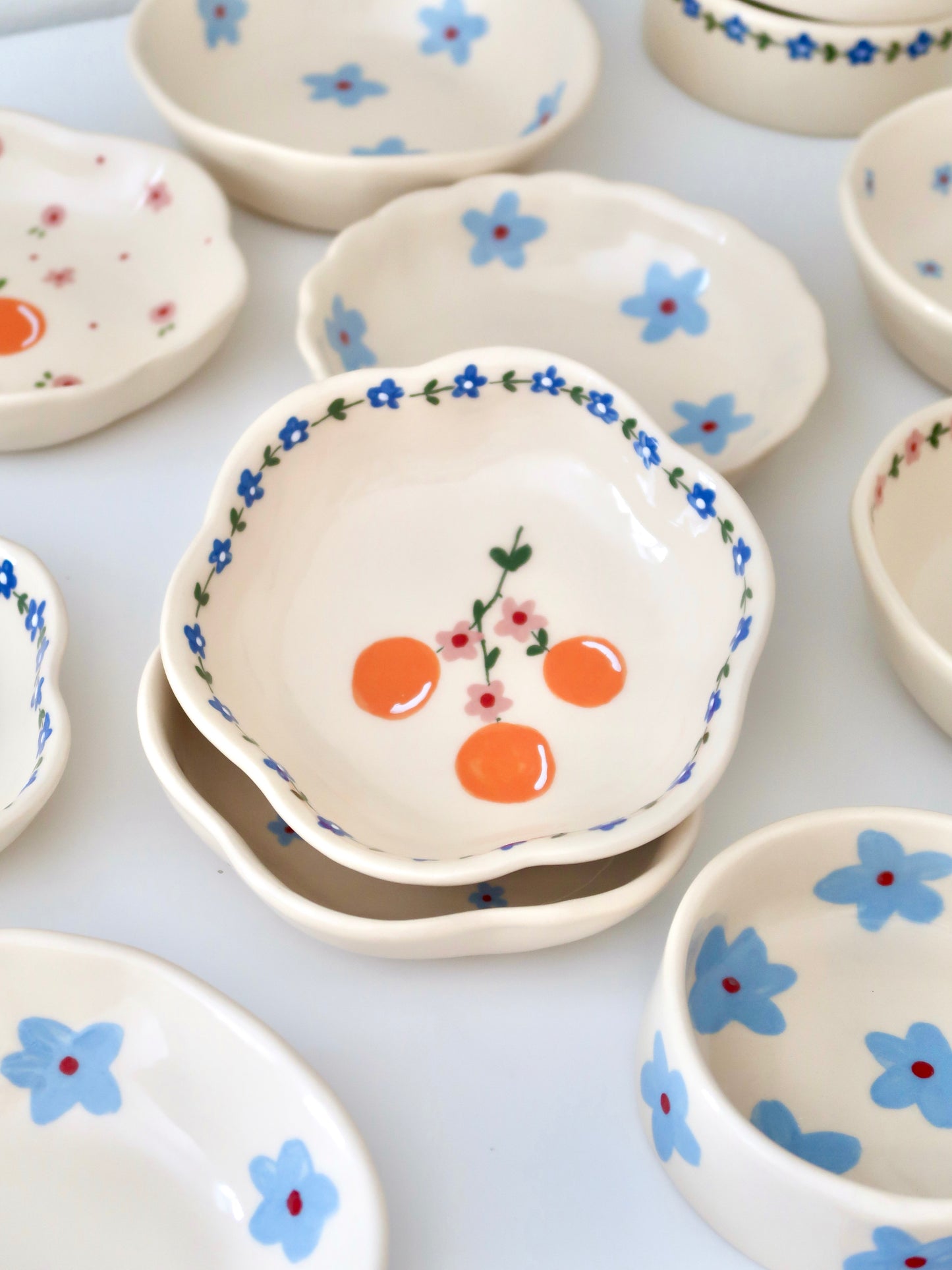Scalloped bowl with oranges and blue flowers
