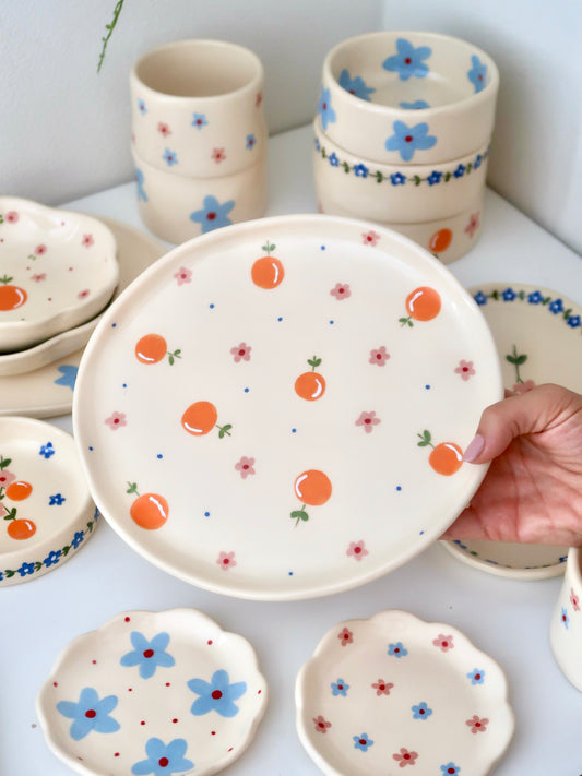 Plate with oranges, pink flowers and blue dots