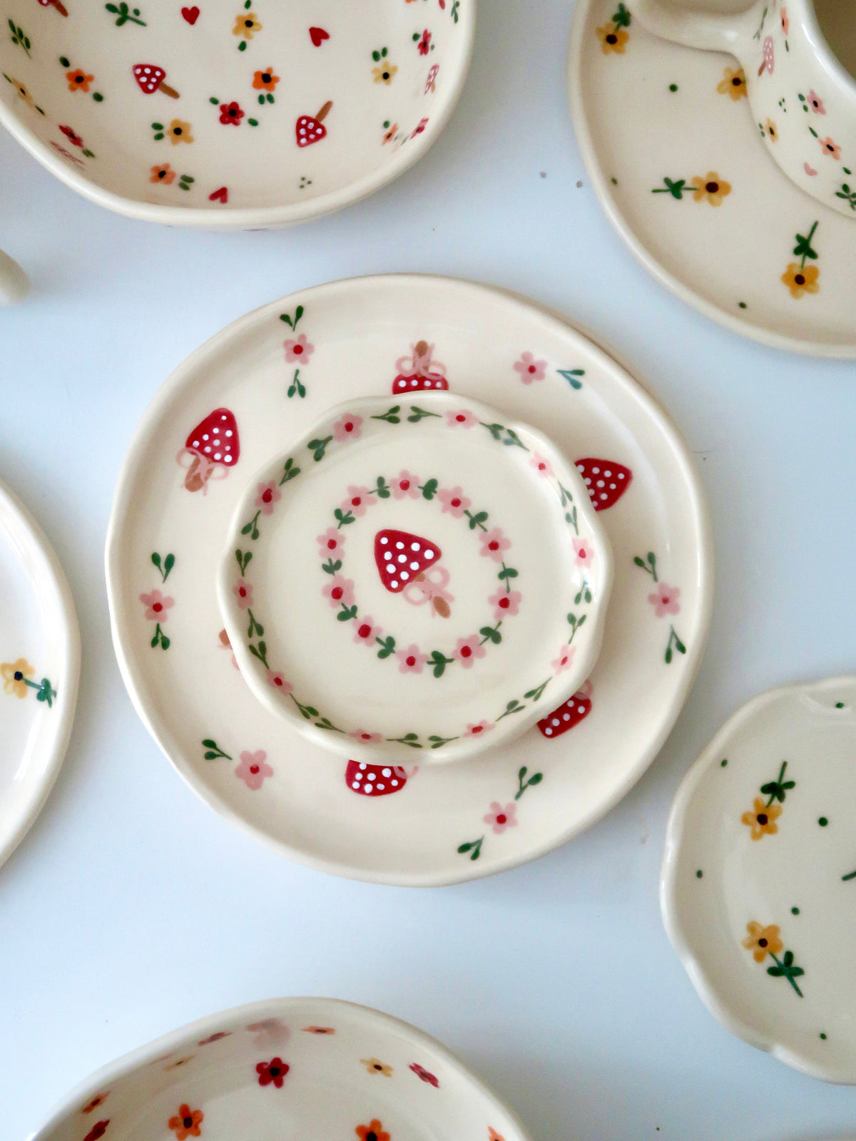 Scalloped ring dish with a mushroom and pink flowers