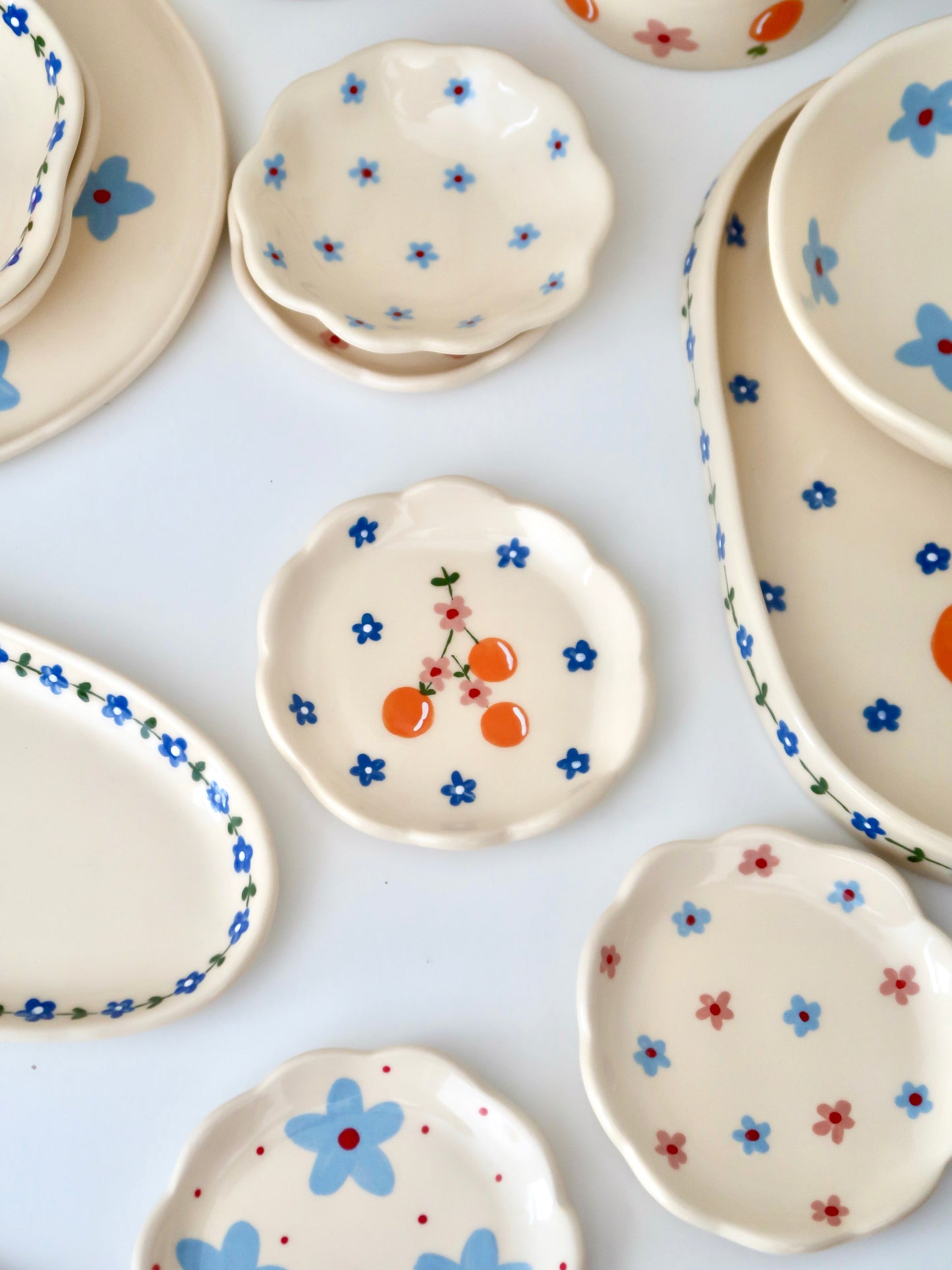 Scalloped ring dish with oranges and blue flowers