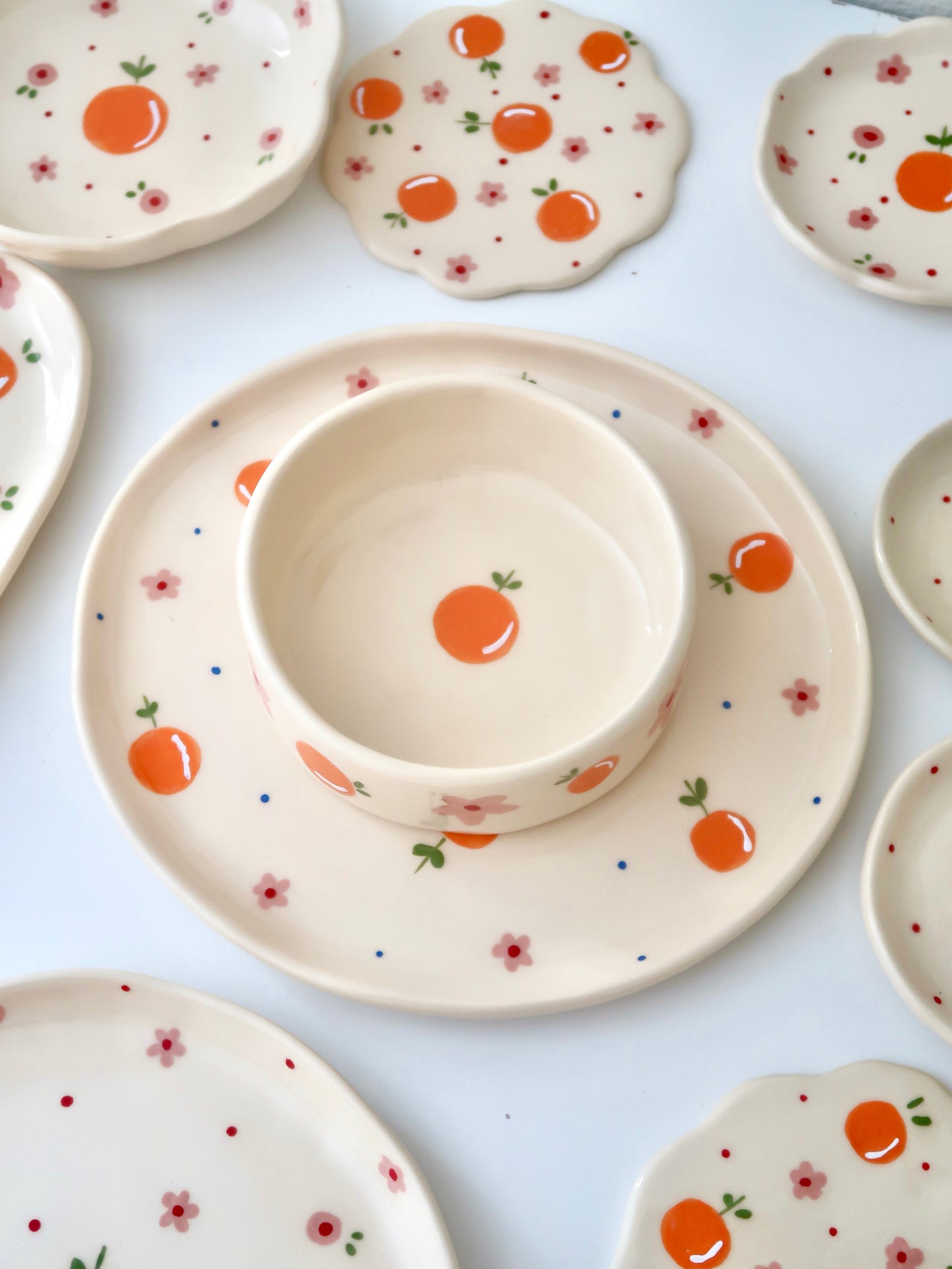 Plate with oranges, pink flowers and blue dots