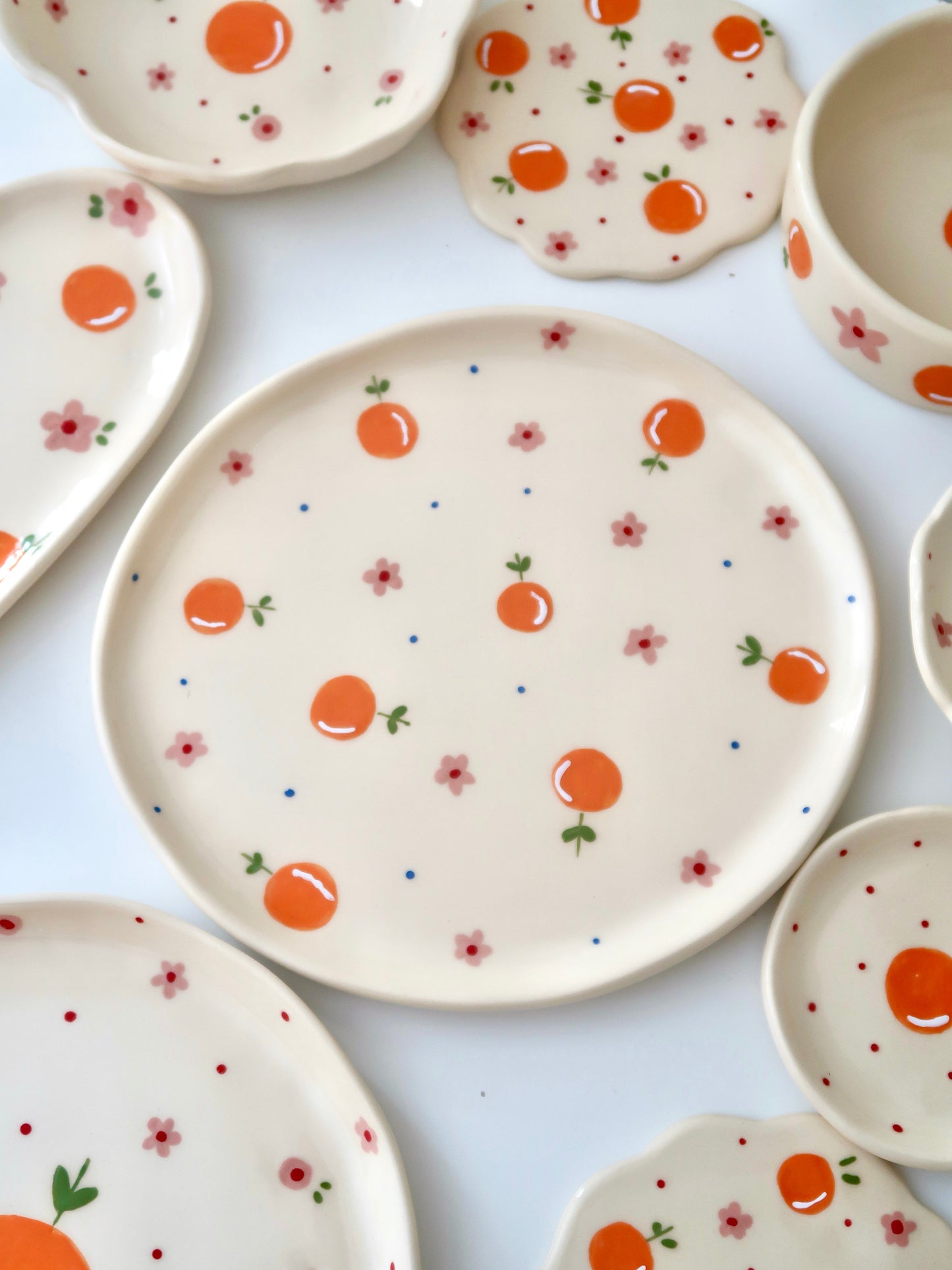 Plate with oranges, pink flowers and blue dots